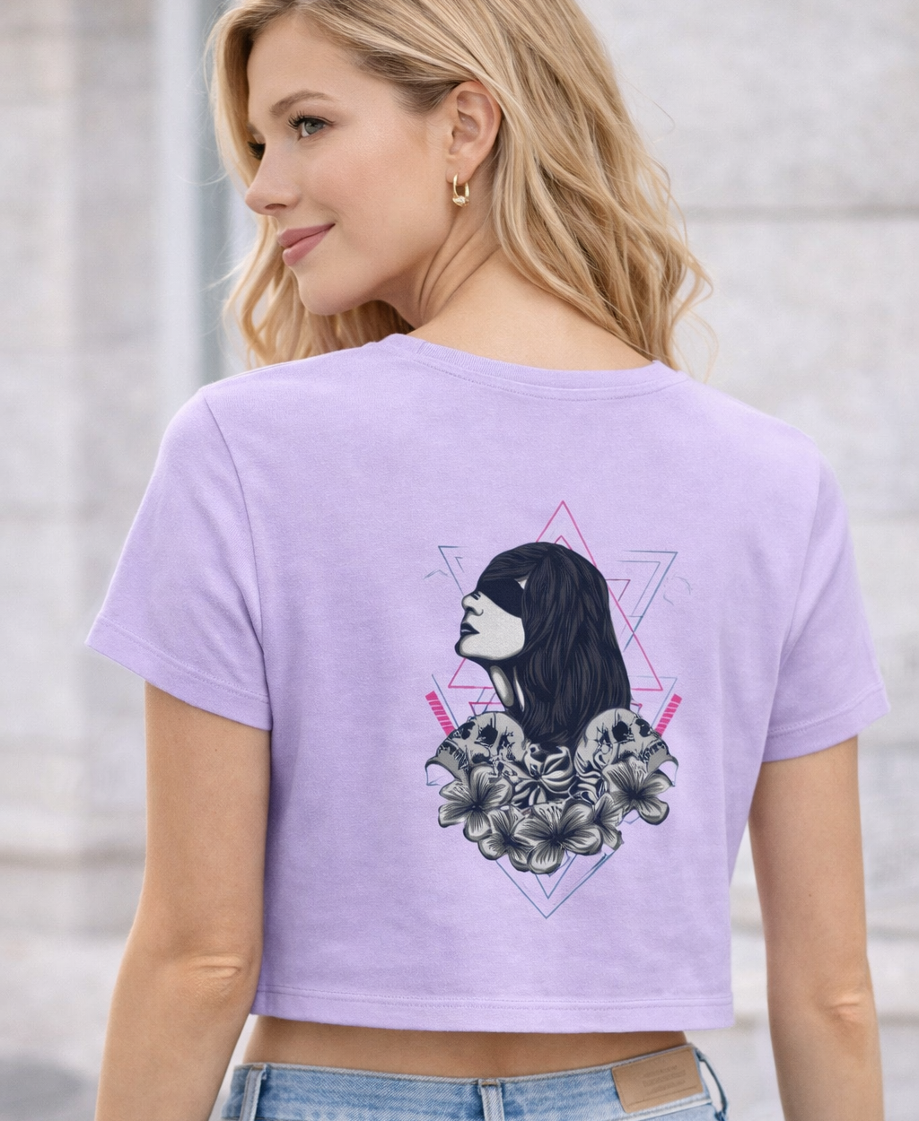 Person wearing a light purple t-shirt with a graphic design, standing against a neutral background.