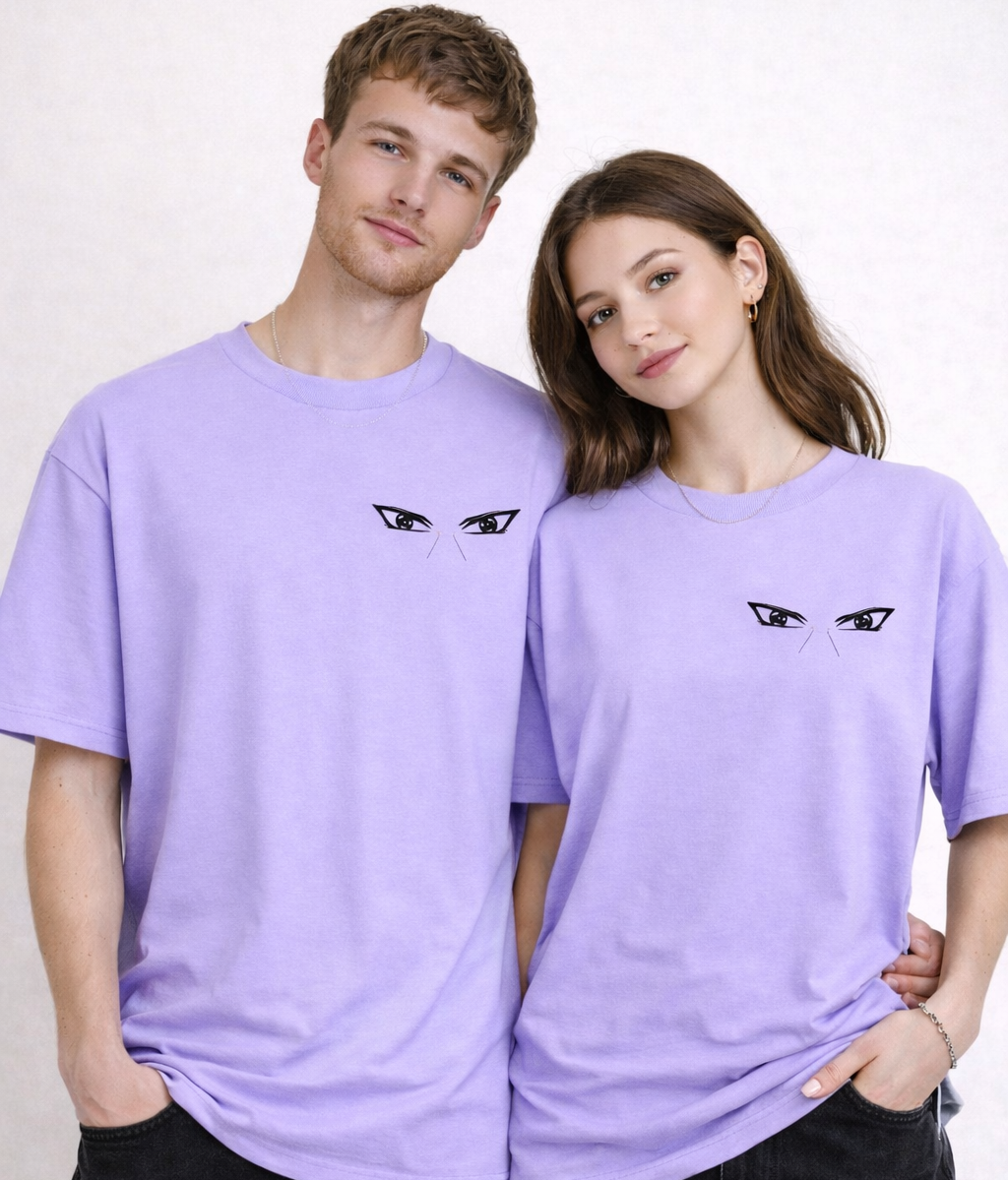 Two people wearing matching purple t-shirts with a black eye design