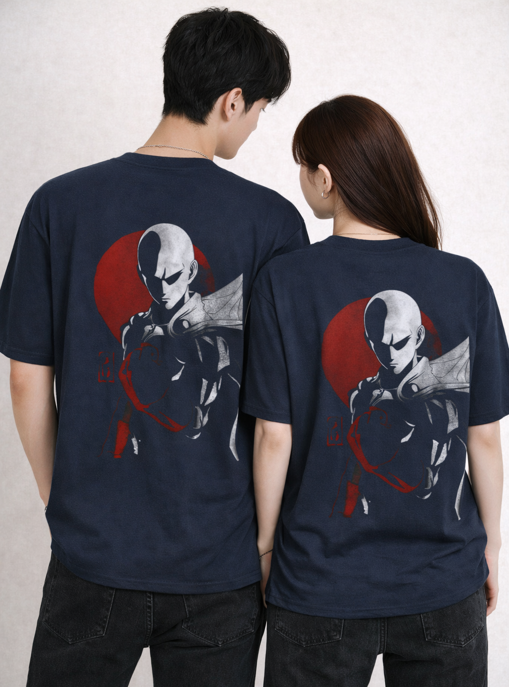 Two people wearing navy blue t-shirts with a graphic design on the back.